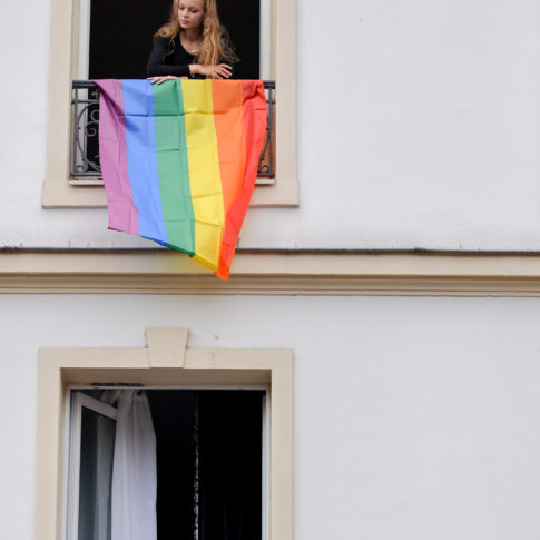 Drapeau exposé sur le balcon avec une famille qui regarde les manifestants